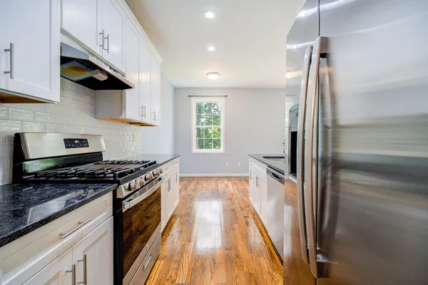 a kitchen with granite countertop a stove and a refrigerator
