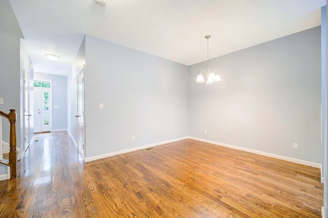 a view of a room with wooden floor and a ceiling fan