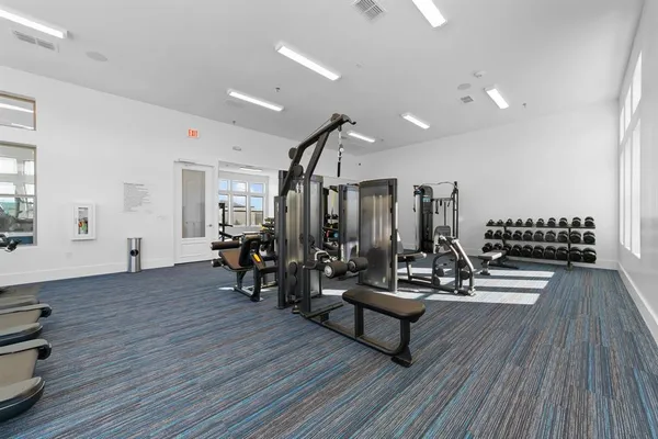 a view of a room with gym equipment and wooden floor