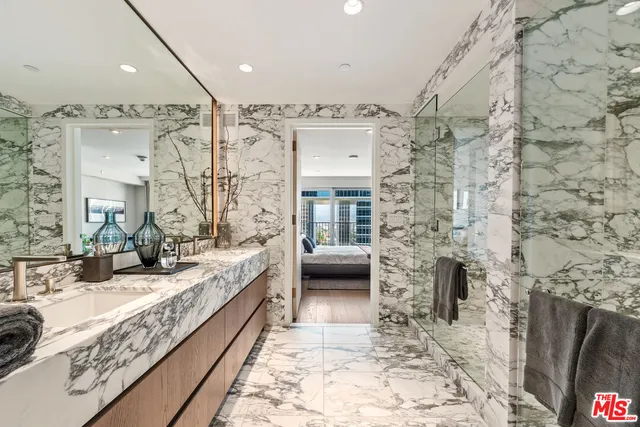 a bathroom with a granite countertop sink a mirror and shower