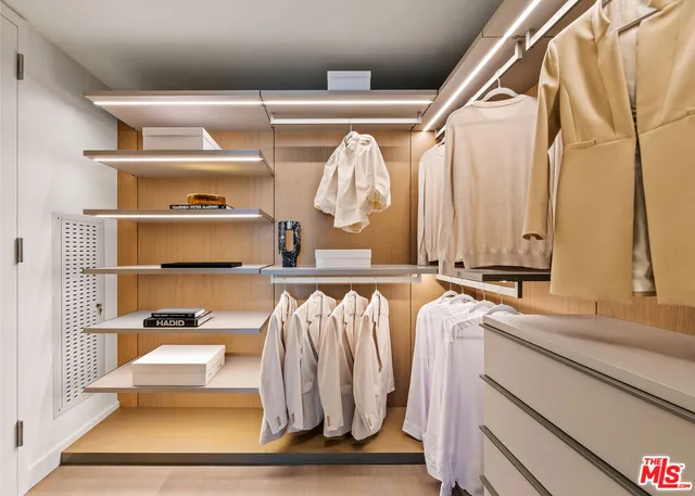 a view of walk in closet with clothes and shoes