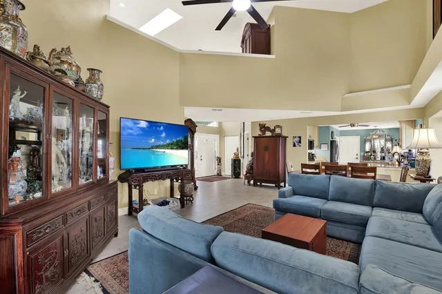 a living room with furniture kitchen view and a wooden floor