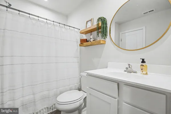 a bathroom with a sink a toilet and a mirror