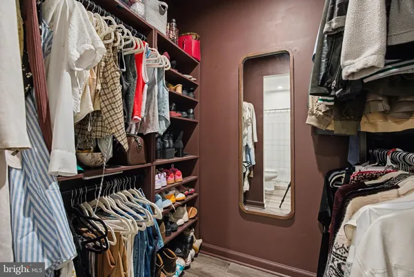 a view of walk in closet with clothes and shoes