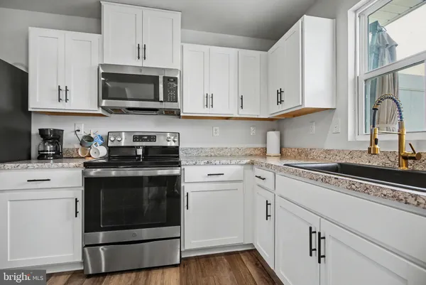 a kitchen with white cabinets stainless steel appliances and sink
