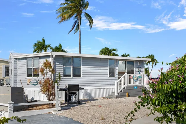 a front view of a house with a tree
