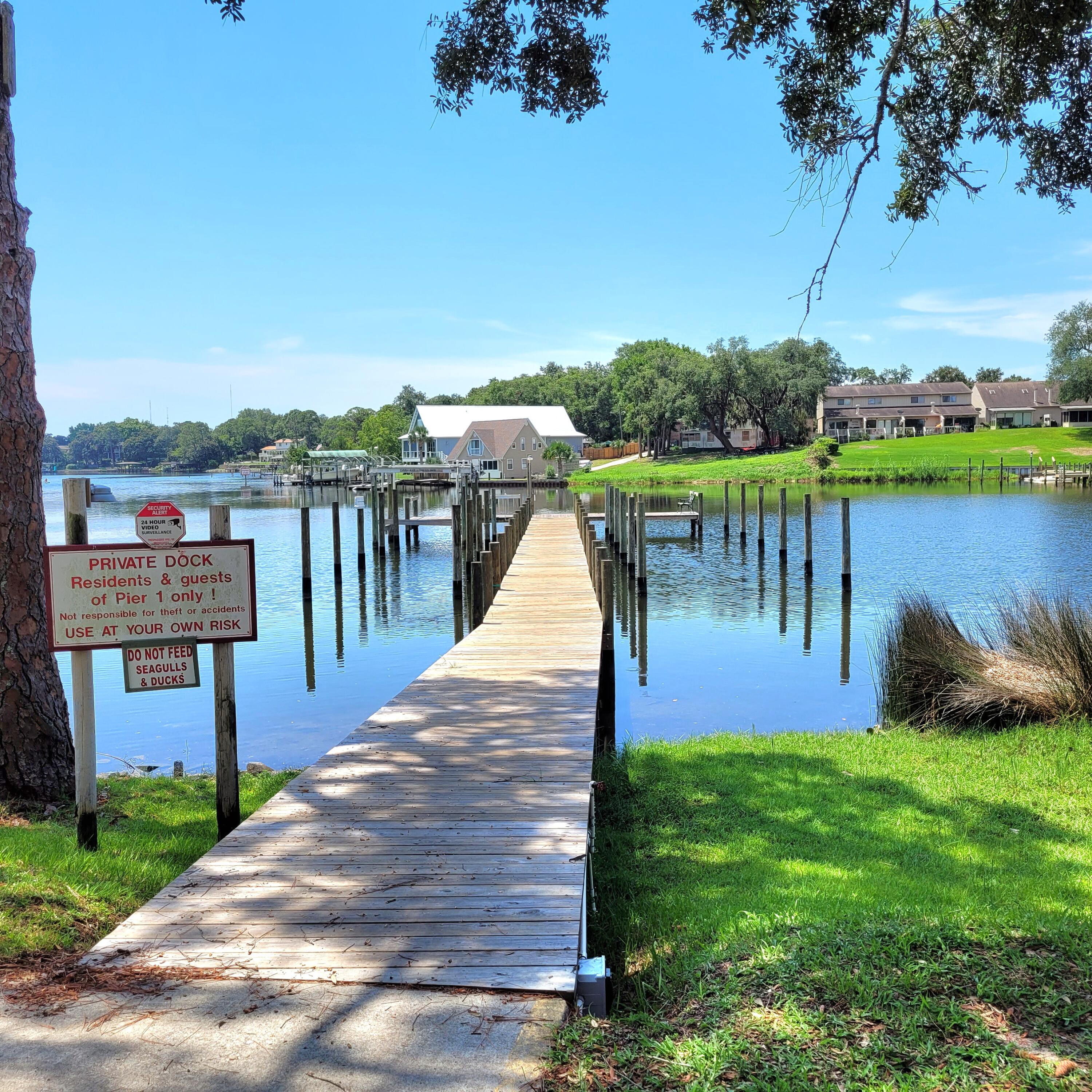 210 Pelham Road, Unit 208C Fort Walton Beach, FL 32547 - Photo 15 of 17 a park view with a bench under palm trees