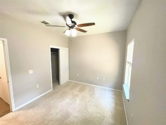 a view of a room with a ceiling fan and a window