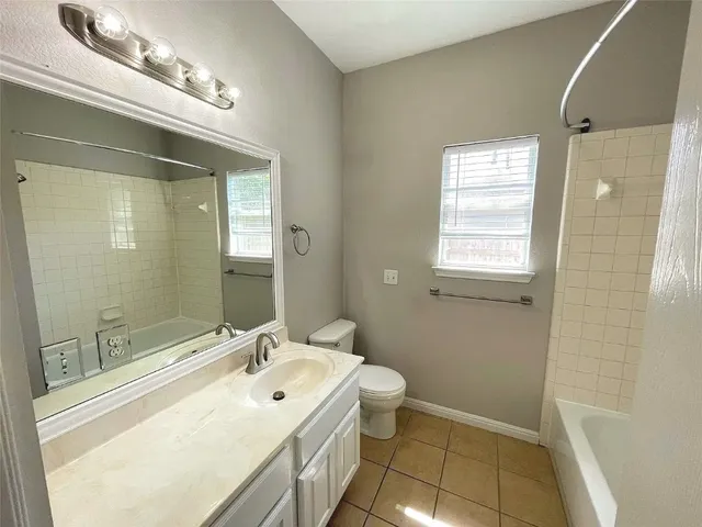 a bathroom with a granite countertop sink a toilet and mirror