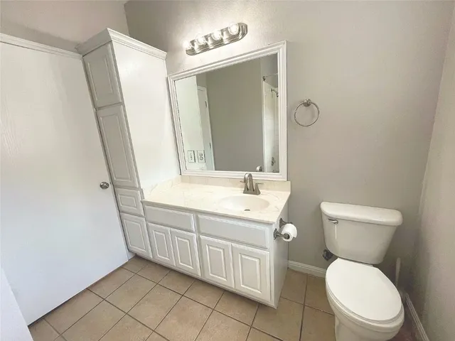 a bathroom with a toilet a sink a mirror and vanity