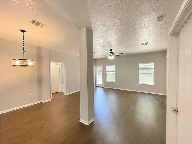 a view of a room with wooden floor and ceiling fan