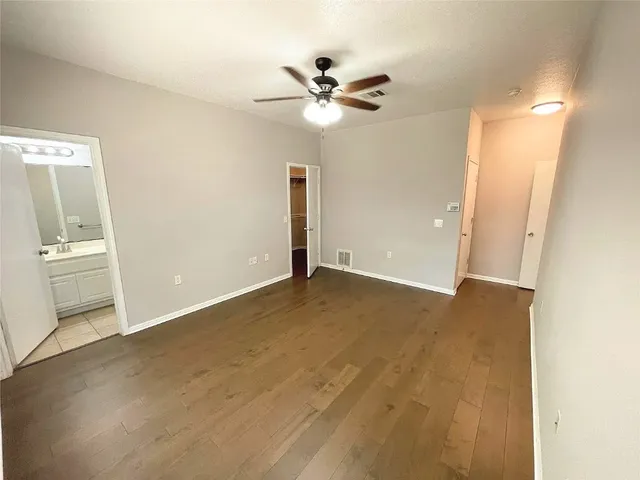 an empty room with a ceiling fan and a window