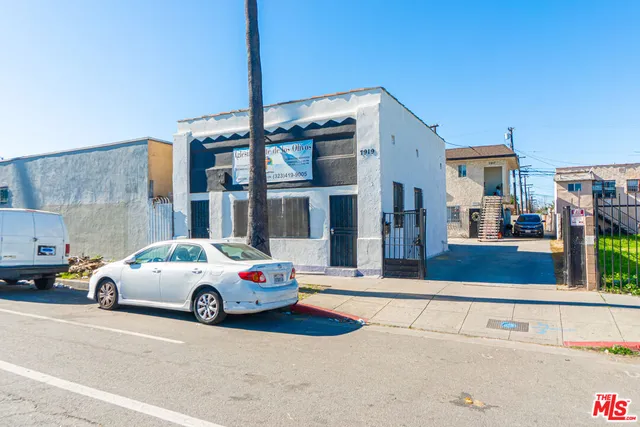 a white building that has a lots of car parked on it