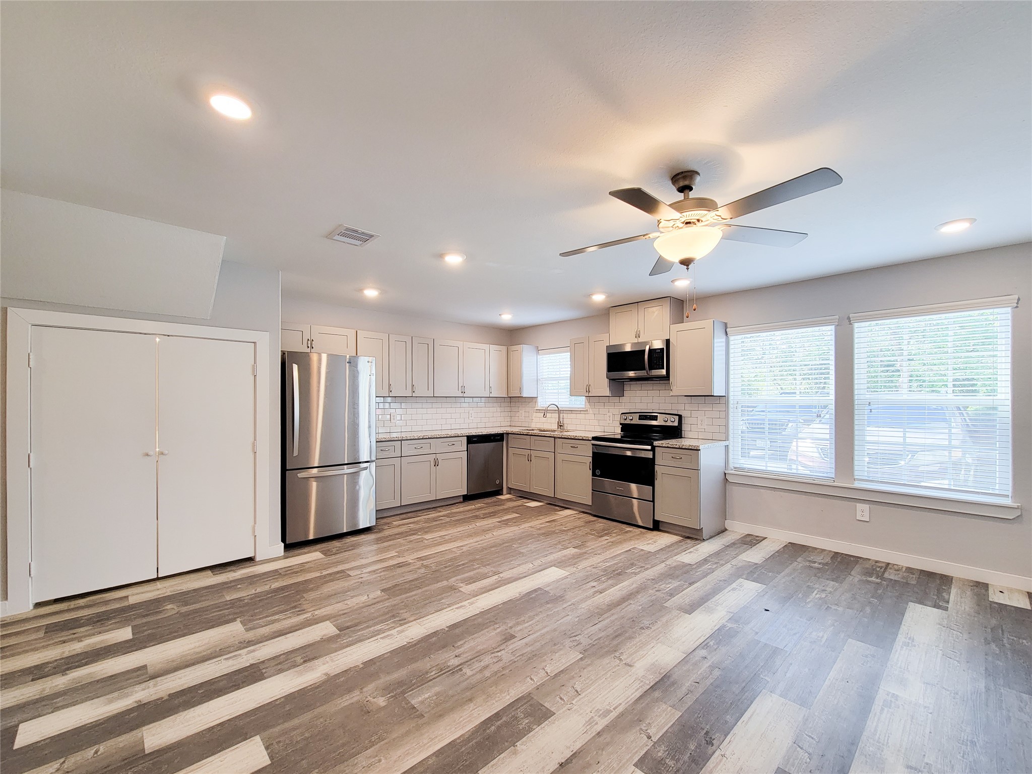 7202 Sandle Street, Unit A Houston, TX 77088 - Photo 5 of 29 a open kitchen with kitchen island a stove a sink dishwasher and a refrigerator with wooden floor