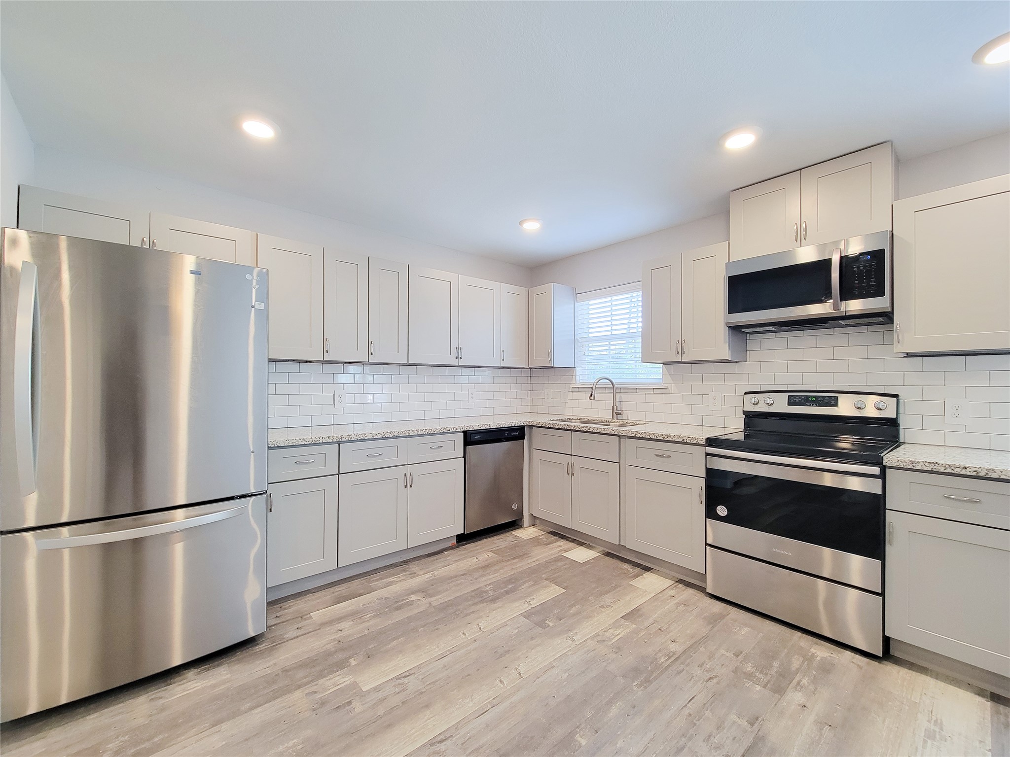 7202 Sandle Street, Unit A Houston, TX 77088 - Photo 8 of 29 a kitchen with granite countertop white cabinets and stainless steel appliances