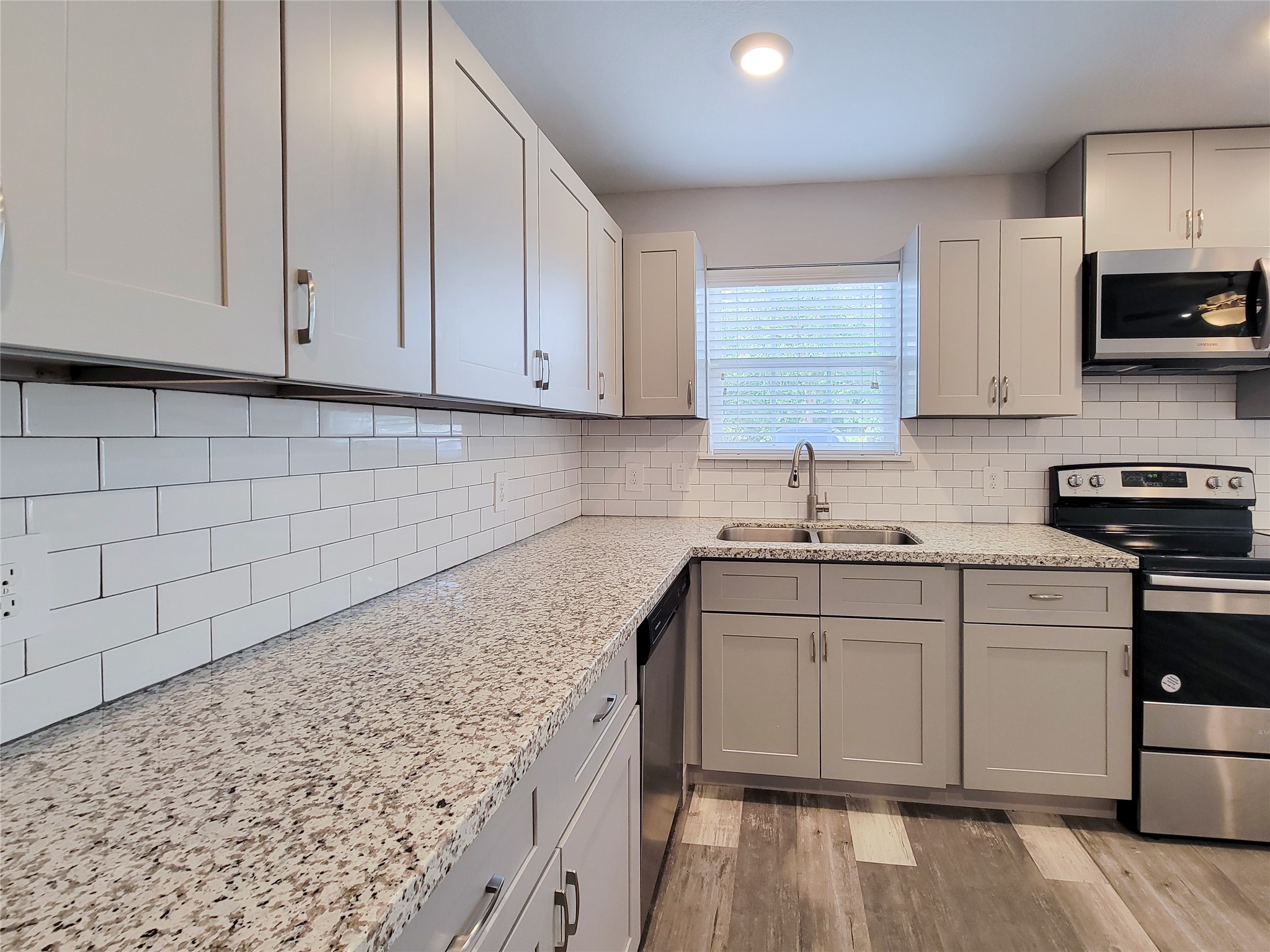 7202 Sandle Street, Unit A Houston, TX 77088 - Photo 10 of 29 a kitchen with stainless steel appliances granite countertop a sink stove and microwave