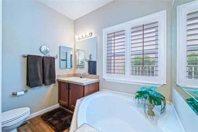 a bathroom with a sink vanity granite toilet and a mirror