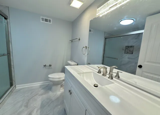 a bathroom with a sink a toilet and shower