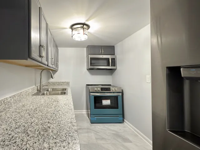 a kitchen with stainless steel appliances granite countertop a stove and a sink