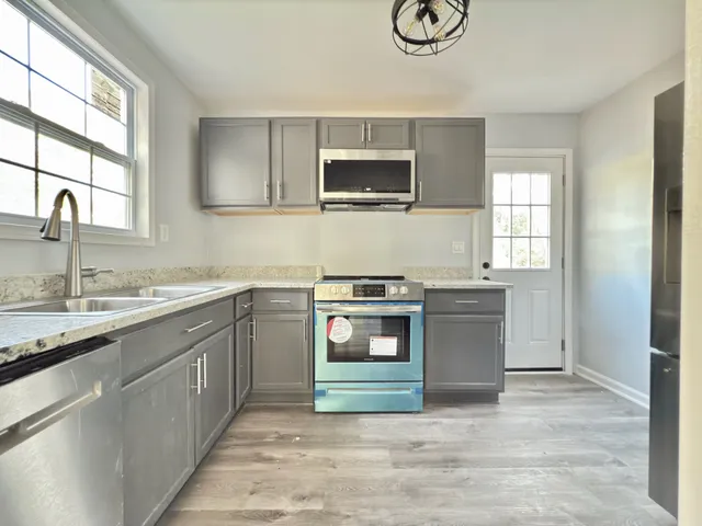 a kitchen with stainless steel appliances granite countertop a sink and a stove top oven