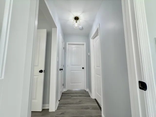 a view of a hallway with wooden floor and closet area