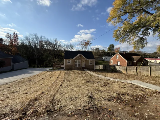 a view of house with yard and sitting area