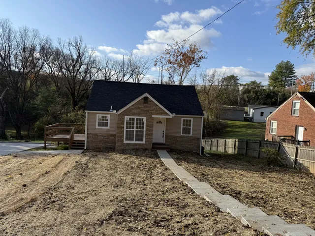 a front view of a house with a yard covered with snow