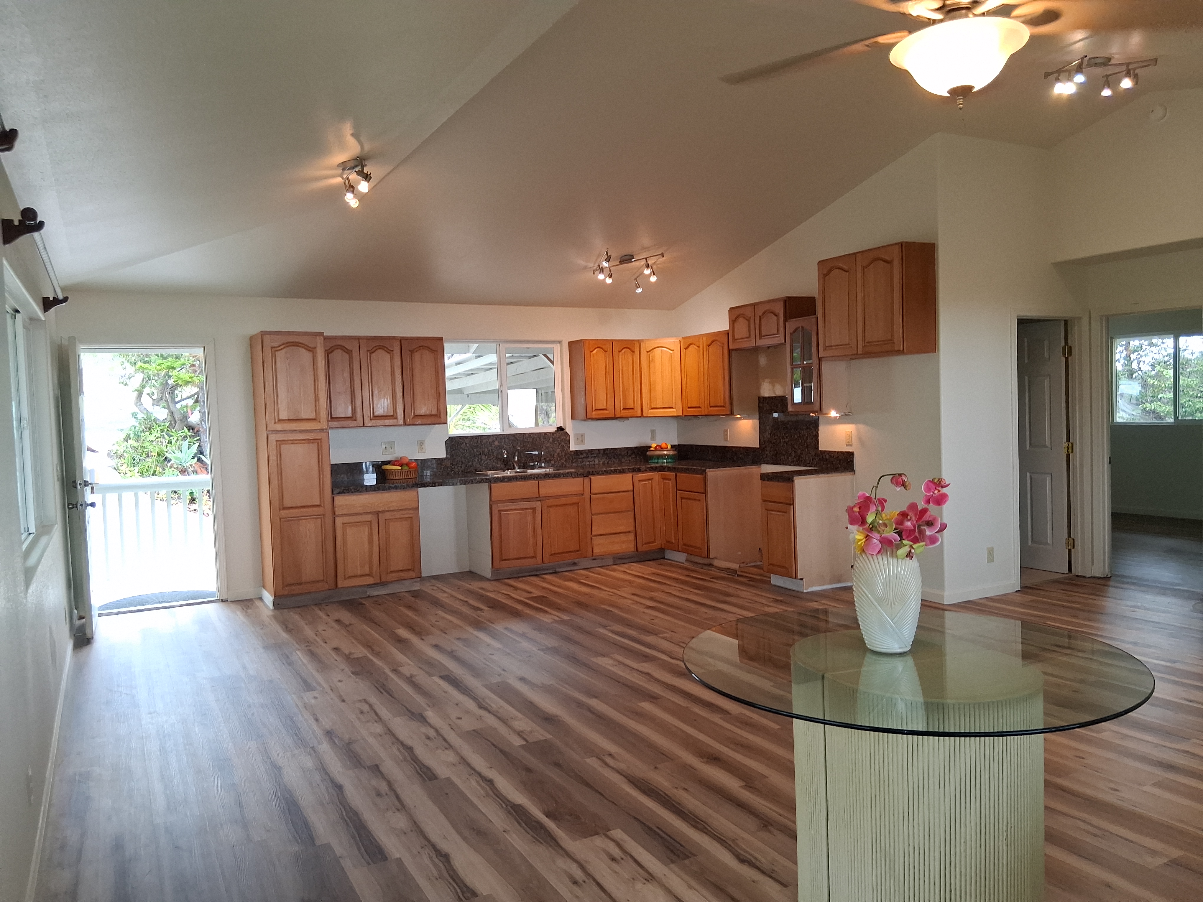92-8221 Reef Parkway Ocean View, HI 96704 - Photo 8 of 20 a kitchen with stainless steel appliances kitchen island granite countertop a refrigerator a stove top oven a sink dishwasher and wooden floor