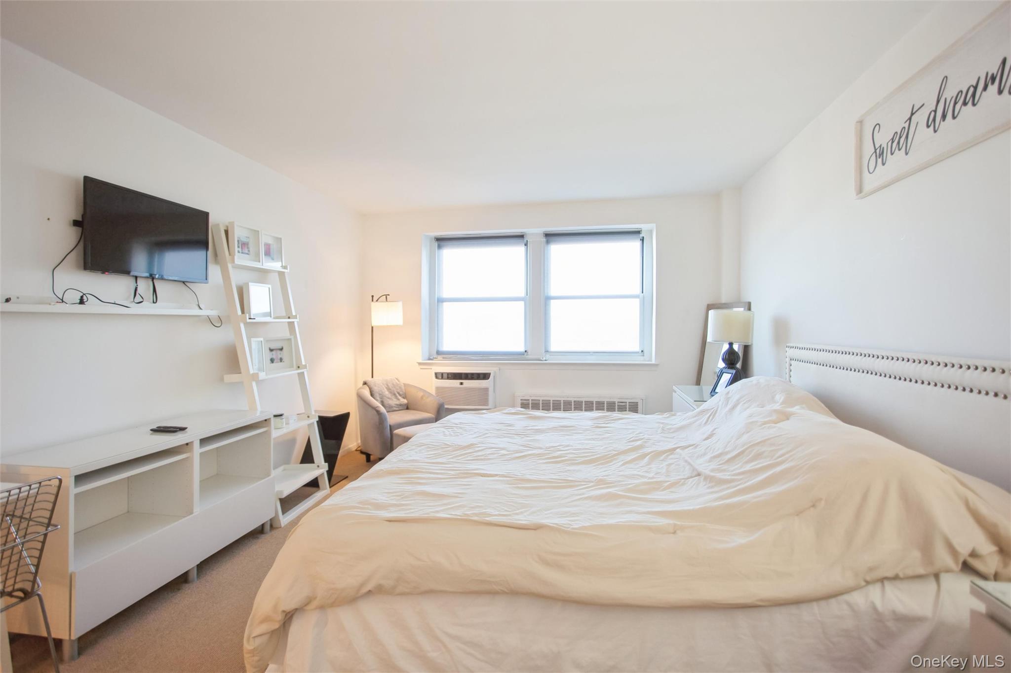 711 Shore Road, Unit 2C Long Beach, NY 11561 - Photo 11 of 27 a bedroom with a bed and a flat screen tv