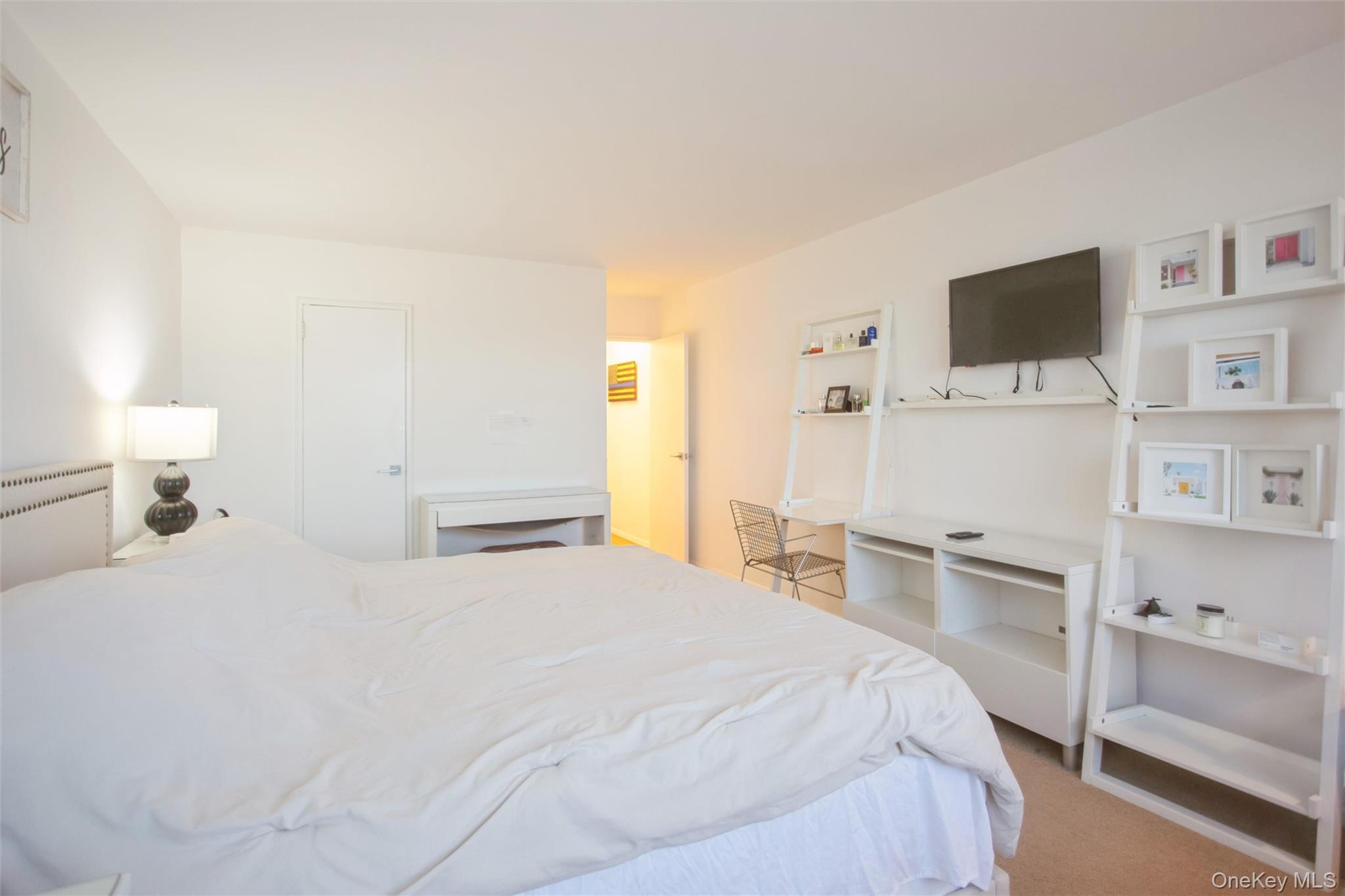 711 Shore Road, Unit 2C Long Beach, NY 11561 - Photo 12 of 27 a bedroom with a bed and a flat screen tv