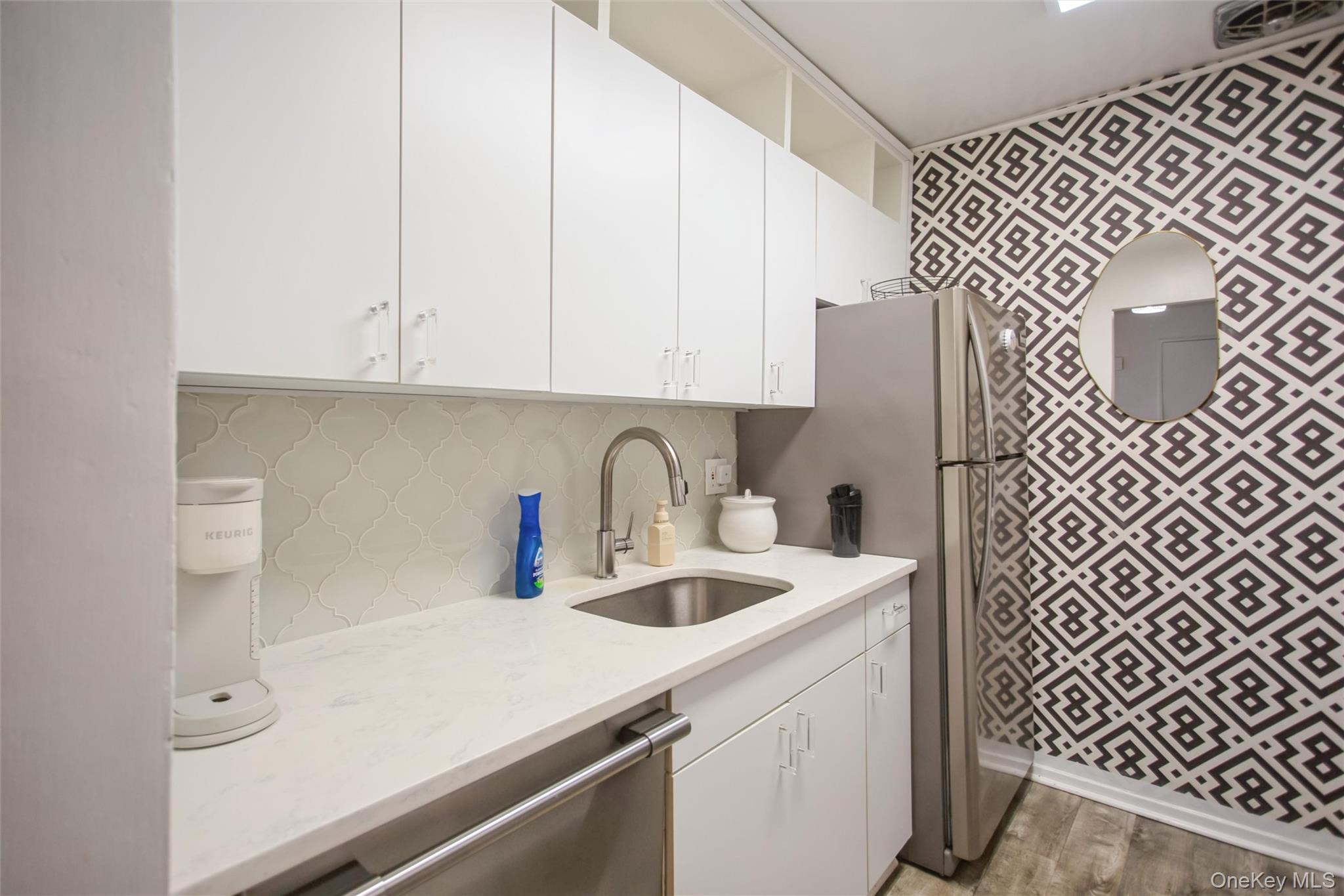711 Shore Road, Unit 2C Long Beach, NY 11561 - Photo 2 of 27 a kitchen with a sink and a refrigerator