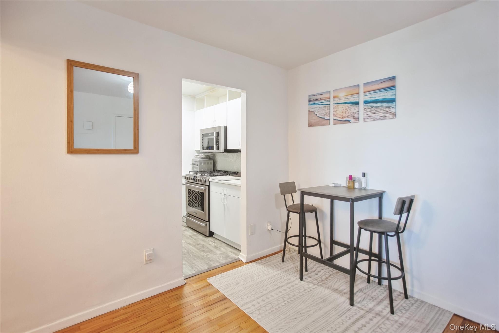 711 Shore Road, Unit 2C Long Beach, NY 11561 - Photo 4 of 27 a view of a dining room with furniture and wooden floor