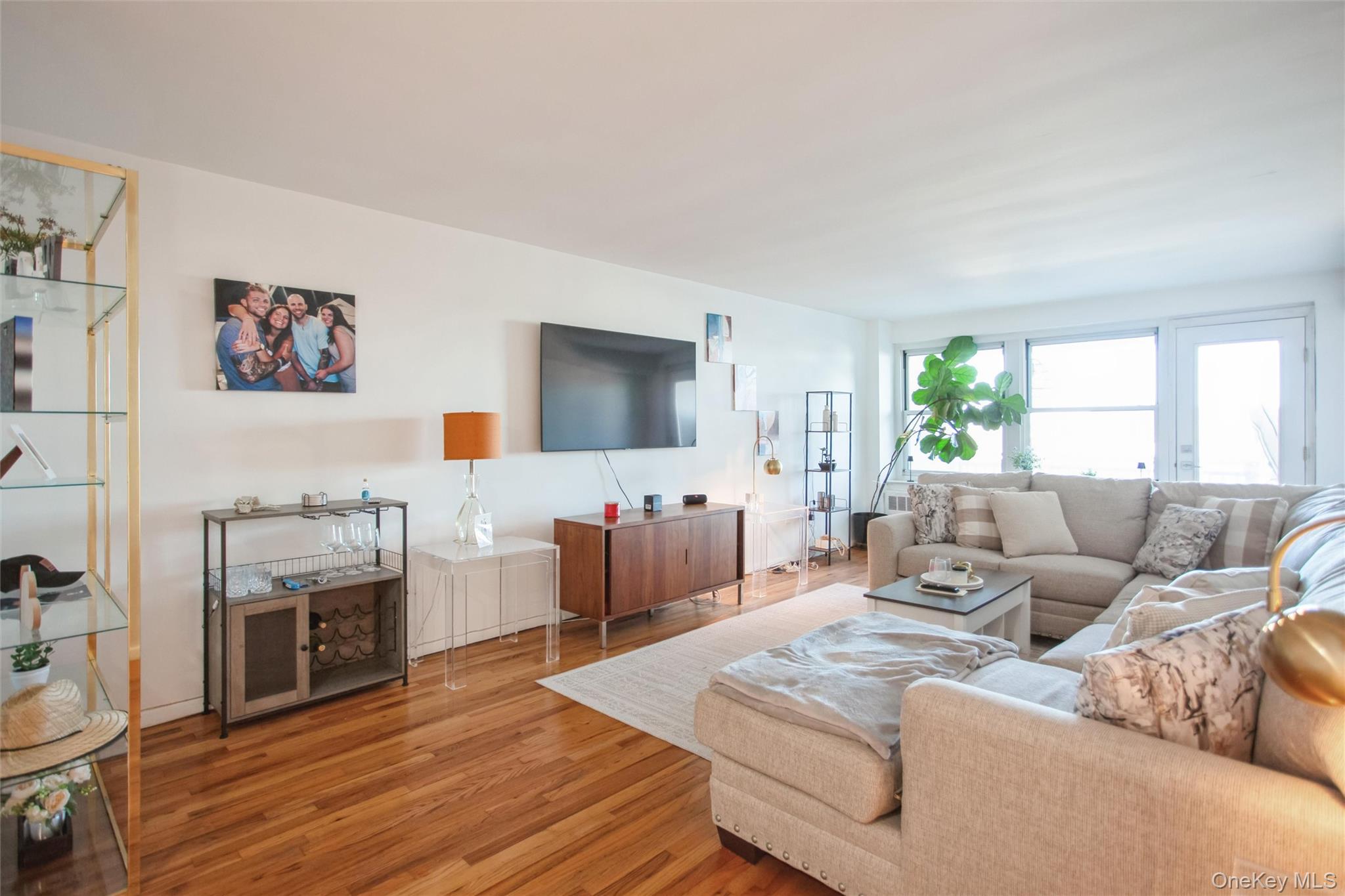 711 Shore Road, Unit 2C Long Beach, NY 11561 - Photo 8 of 27 a living room with furniture and a flat screen tv