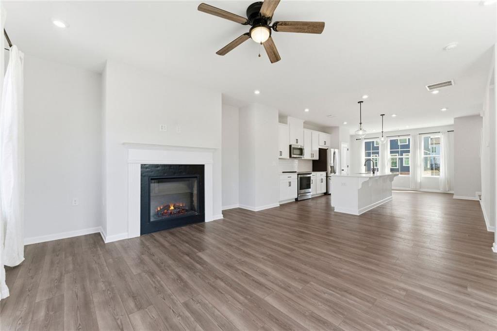 1200 Marlo Way Acworth, GA 30102 - Photo 11 of 34 a view of a living room with wooden floor and a fireplace