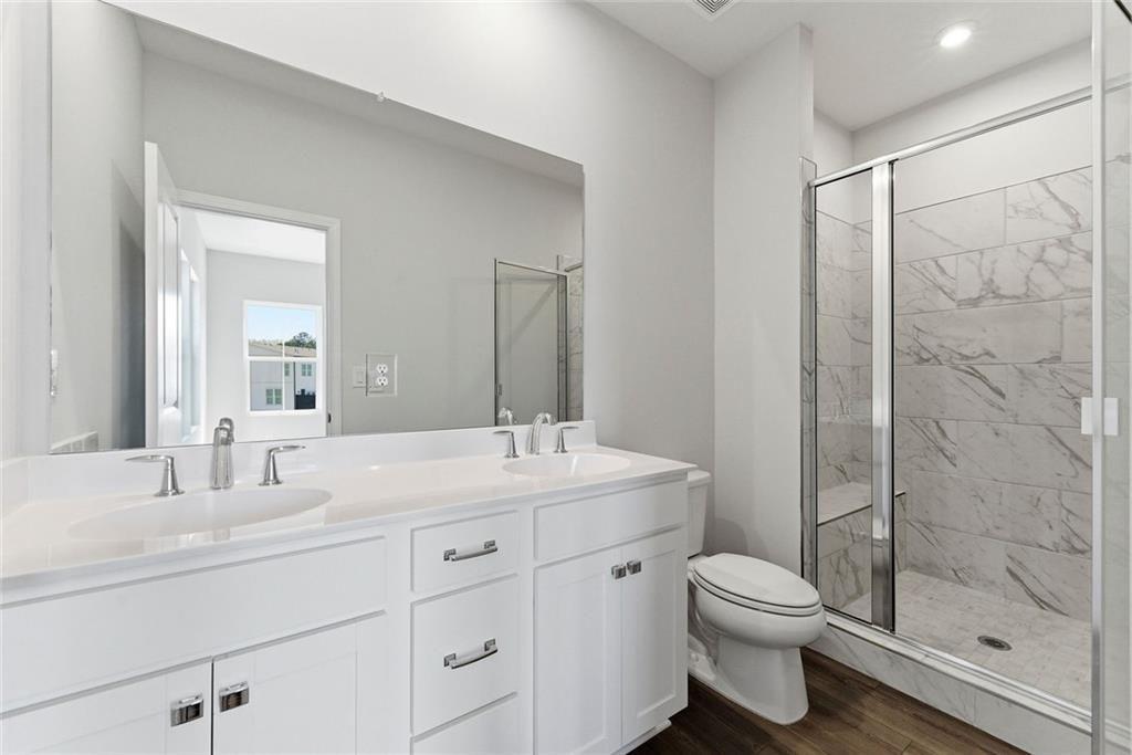 1200 Marlo Way Acworth, GA 30102 - Photo 17 of 34 a bathroom with a toilet a sink a mirror a shower a vanity and window
