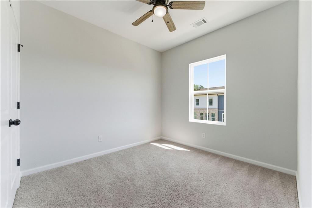 1200 Marlo Way Acworth, GA 30102 - Photo 22 of 34 an empty room with a ceiling fan and window