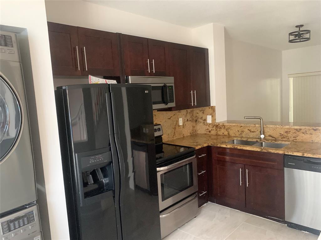12017 Southwest 2nd Street, Unit 12017 Pembroke Pines, FL 33025 - Photo 2 of 13 a kitchen with stainless steel appliances granite countertop a refrigerator and a sink