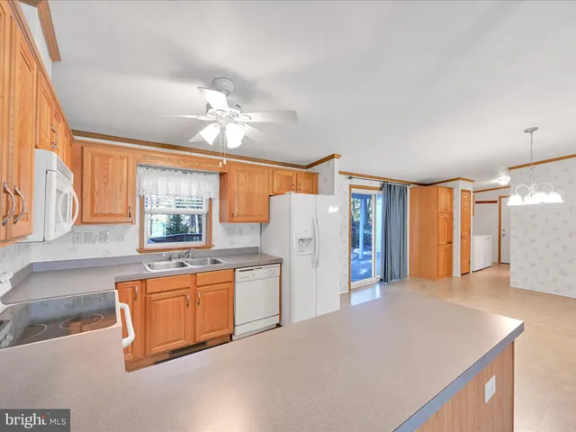 a kitchen with stainless steel appliances a refrigerator a sink dishwasher with a dining table and chairs