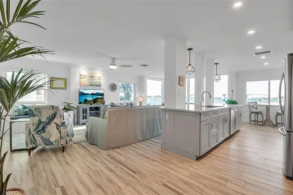 a kitchen with stainless steel appliances a refrigerator a stove a sink cabinets and wooden floor