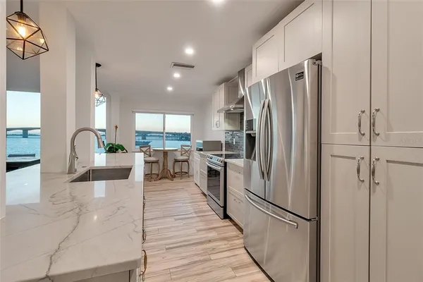 a large kitchen with stainless steel appliances kitchen island granite countertop a large counter top and sink