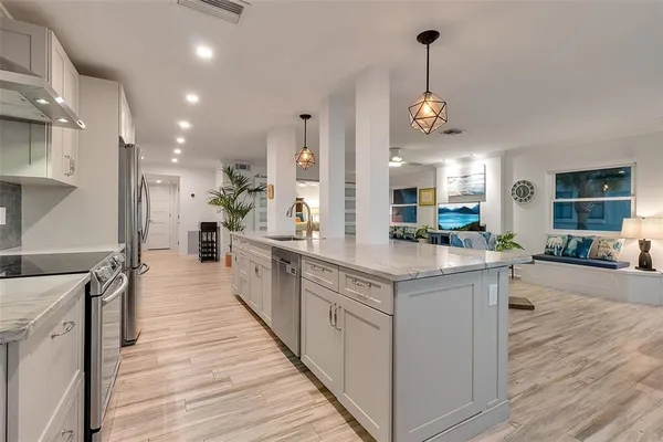a kitchen with stainless steel appliances white cabinets granite counter tops and a hard wood floors