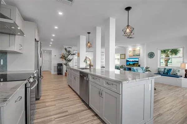 a large kitchen with kitchen island a large counter space appliances and furniture