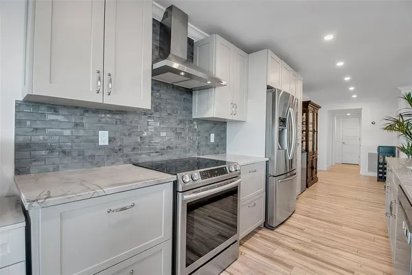 a kitchen with stainless steel appliances granite countertop a refrigerator a oven and a sink