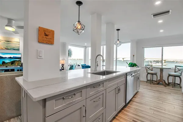 a kitchen with stainless steel appliances granite countertop a refrigerator a oven and a sink