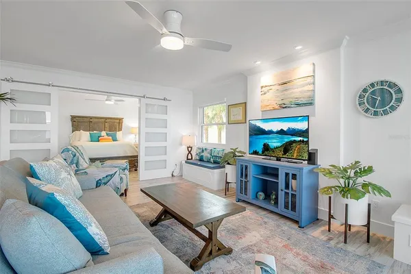 a bed sitting in a bedroom next to a window with a chandelier