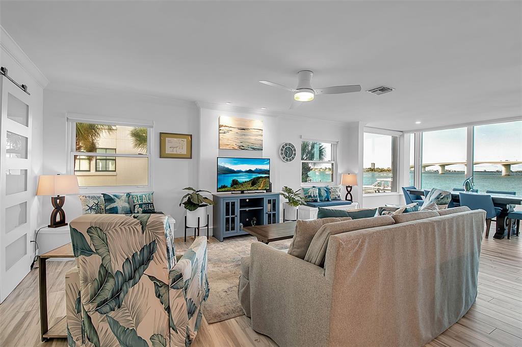226 Golden Gate Point, Unit 21 Sarasota, FL 34236 - Photo 32 of 55 a living room with furniture potted plant a window and a flat screen tv