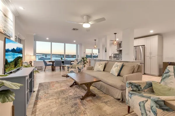 a large white kitchen with lots of counter space and stainless steel appliances
