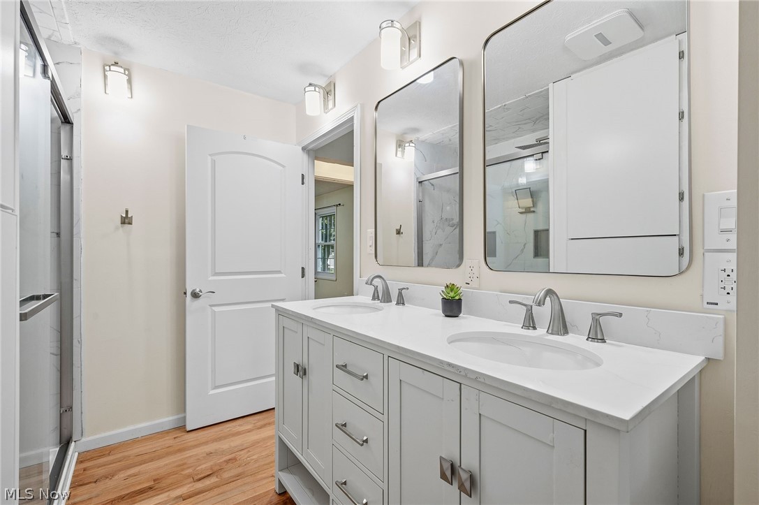 1515 Barlow Road Hudson, OH 44236 - Photo 23 of 31 Primary bedroom bathroom featuring walk-in shower, dual vanities, storage space and natural light.