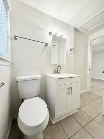 a bathroom with a sink mirror vanity and toilet
