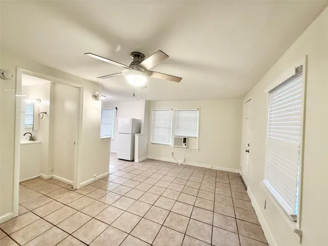 a view of a room with a stylish ceiling fan and entryway